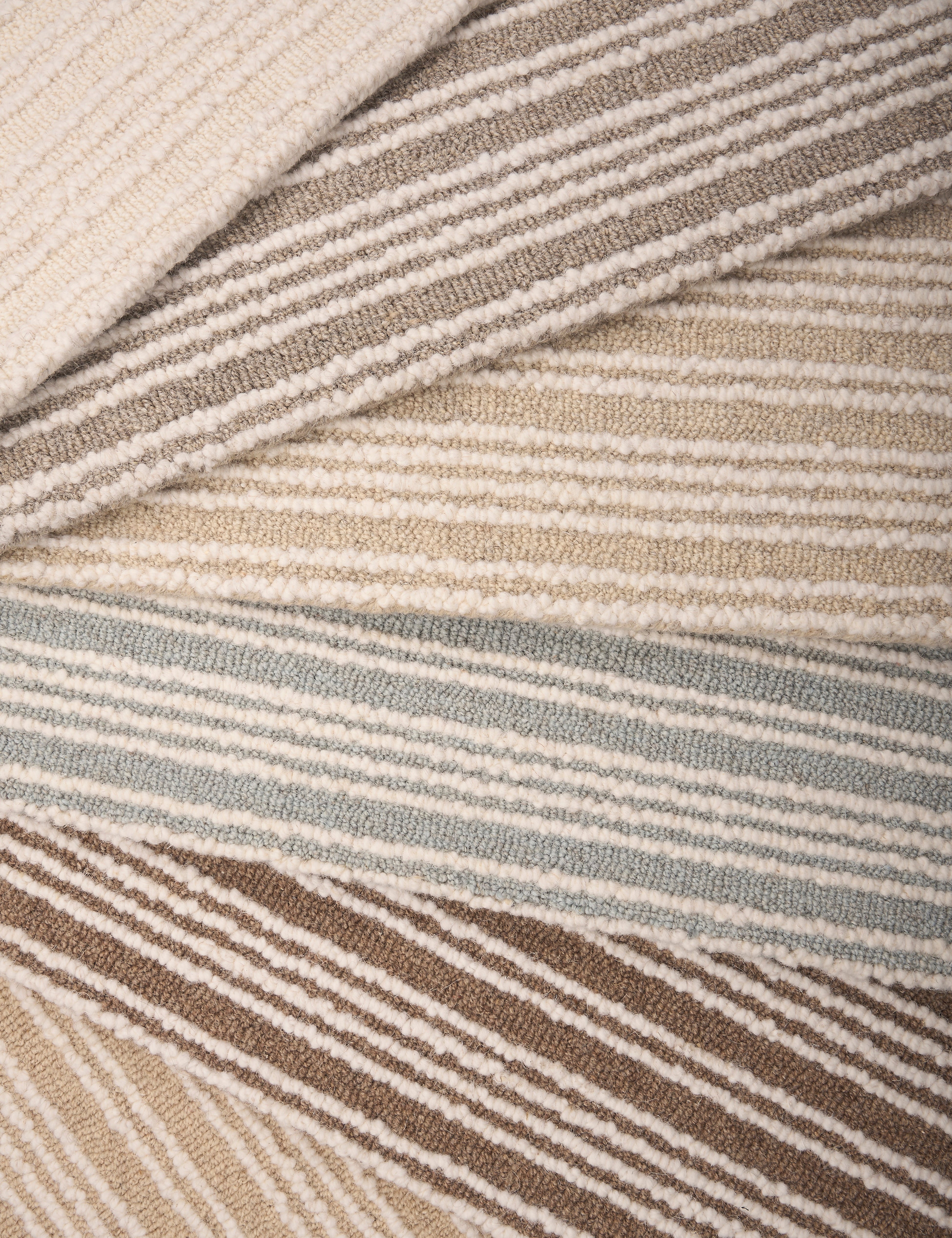 An array of striped broadloom carpets in neutral colors 