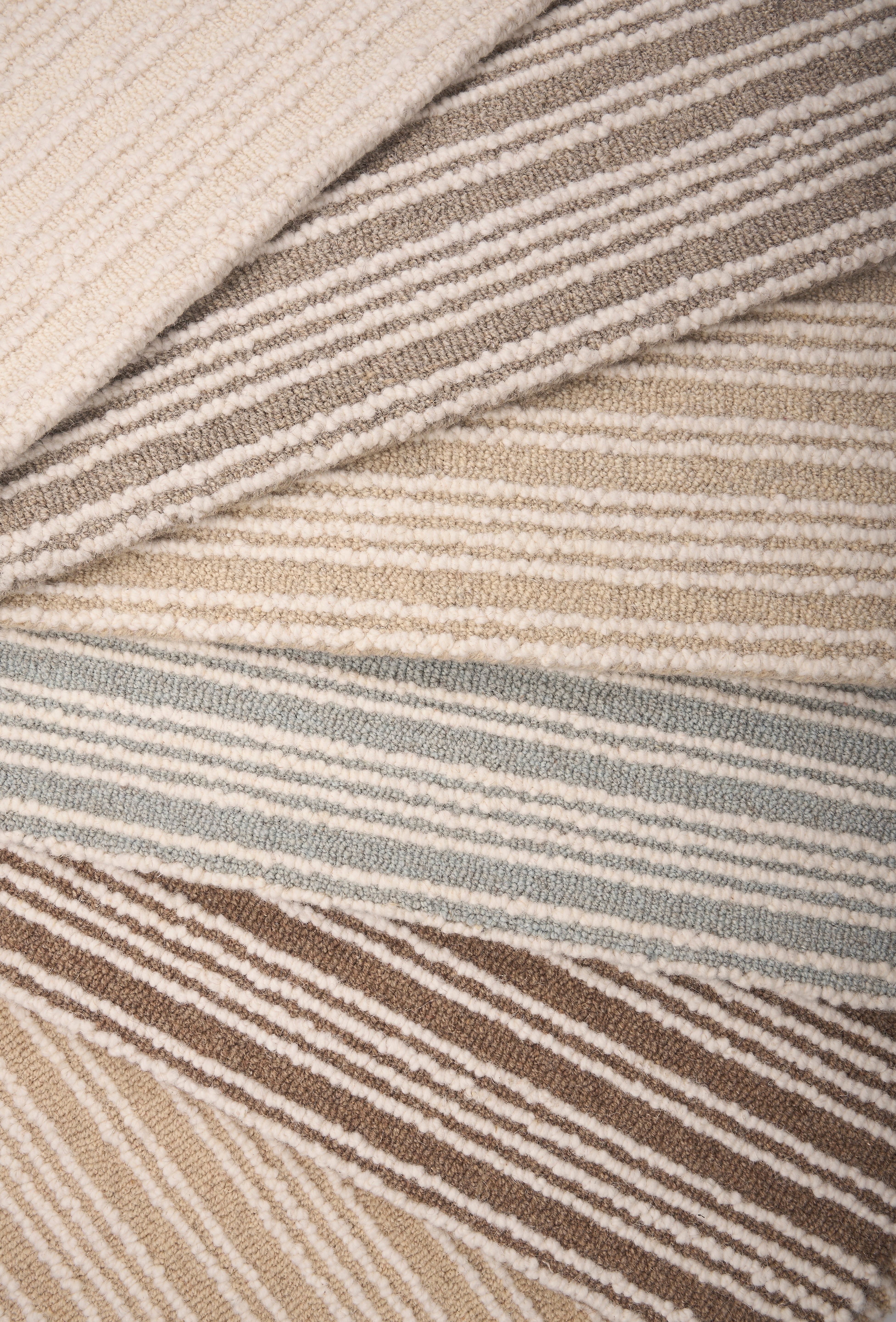 An array of striped broadloom carpets in neutral colors 