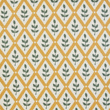 Detail of fabric in a lattice and leaf print in green and yellow on a white field.