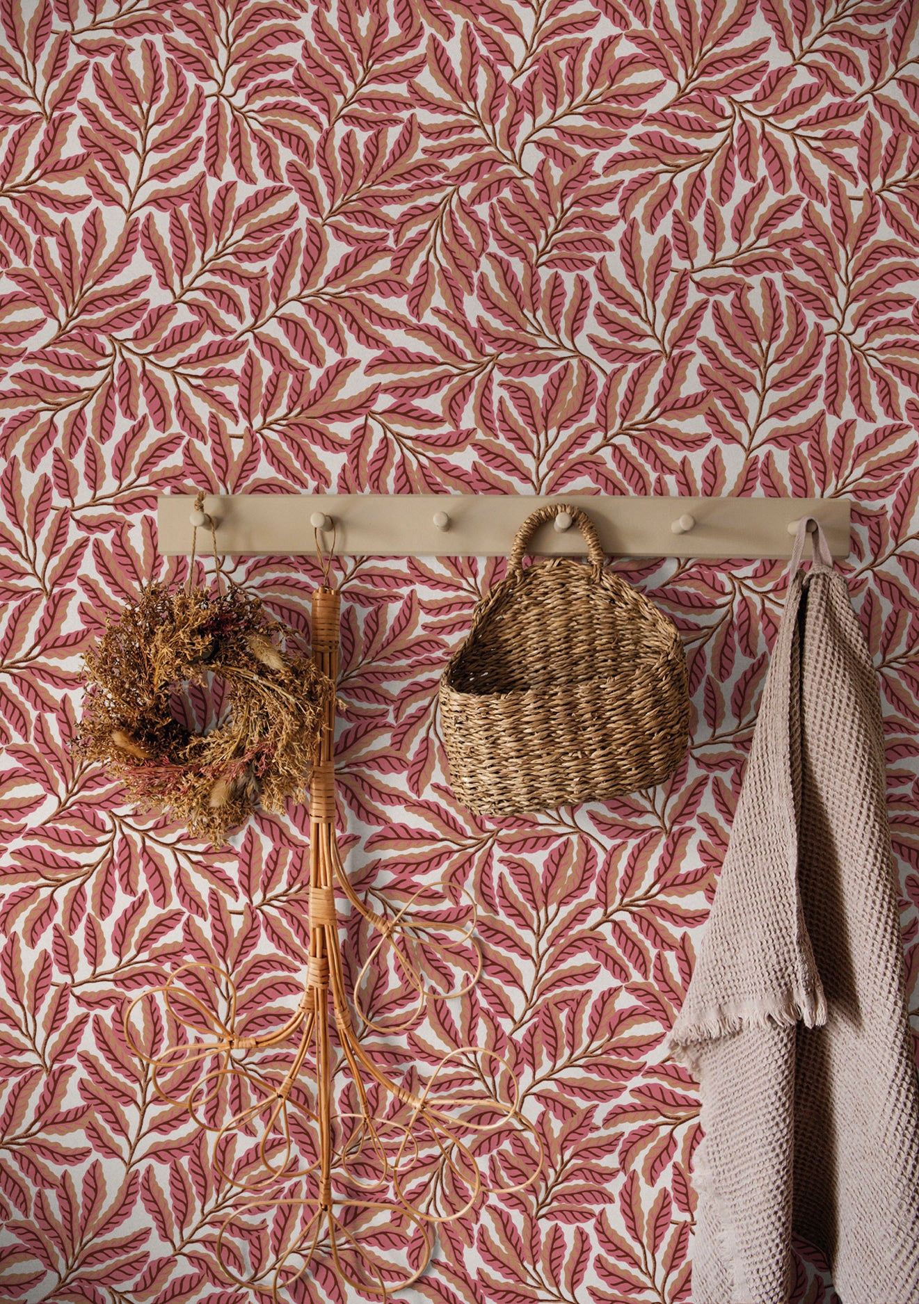 Wall with pink leaf-patterned wallpaper featuring a wooden hook with decorative items.