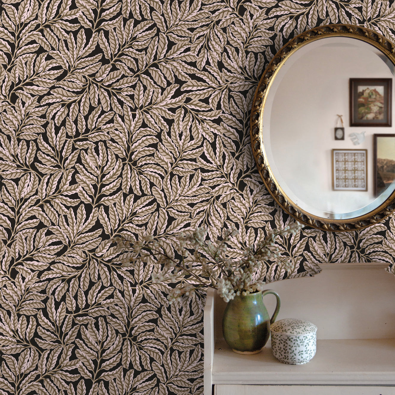 Room interior with leaf-patterned wallpaper, a round mirror, and decorative items.