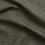 Detail of gently draped printed fabric with watercolor swirling stripe pattern in tonal olive green.