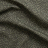 Detail of gently draped printed fabric with watercolor swirling stripe pattern in tonal olive green.