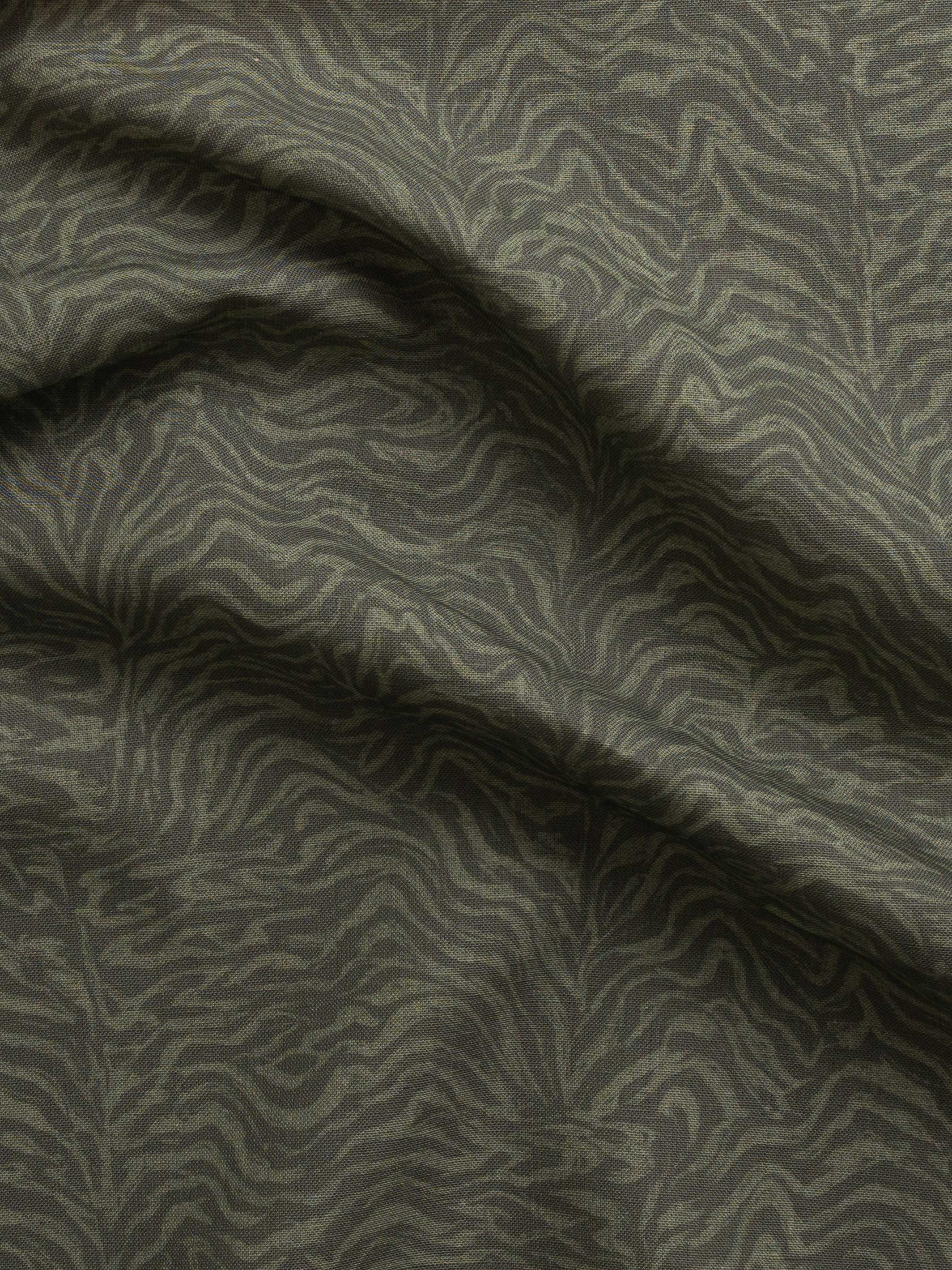 Detail of gently draped printed fabric with watercolor swirling stripe pattern in tonal olive green.