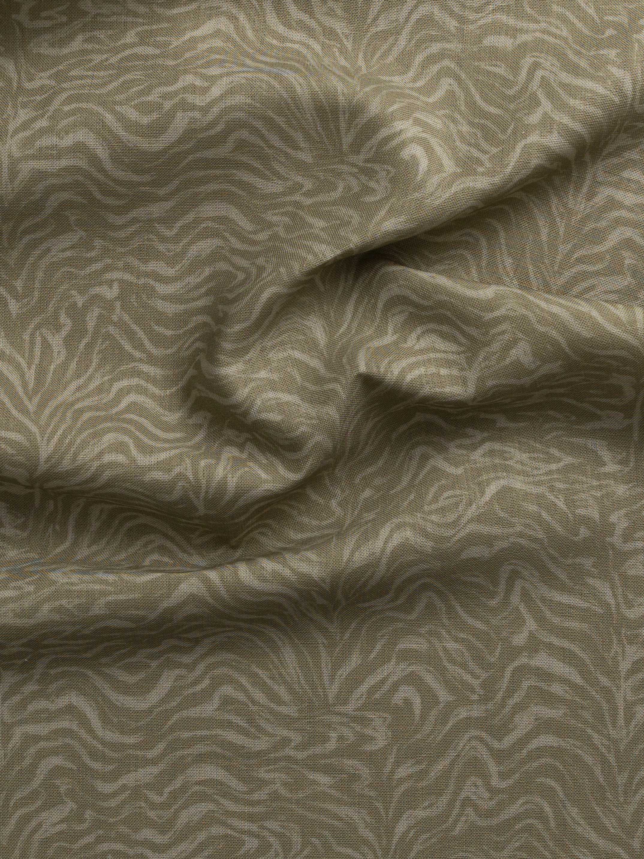 Detail of gently draped printed fabric with watercolor swirling stripe pattern in tonal muted sage green.