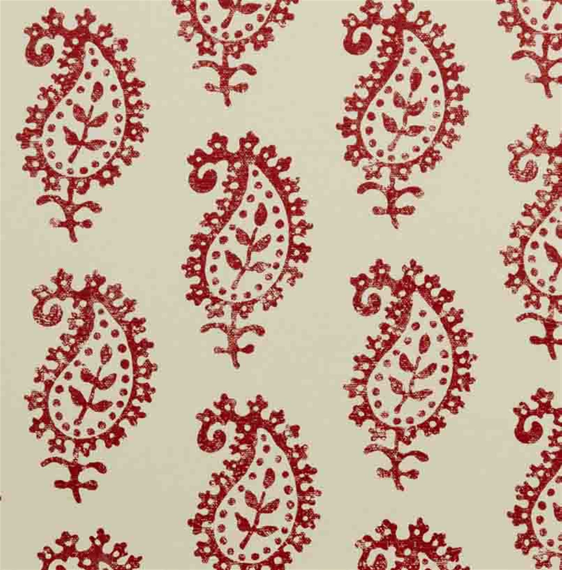 Detail of fabric in a repeating paisley print in red on a cream field.