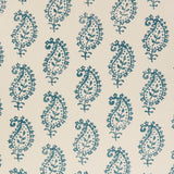 Detail of fabric in a repeating paisley print in navy on a cream field.