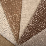 Array of textured carpet samples in neutral colors. 