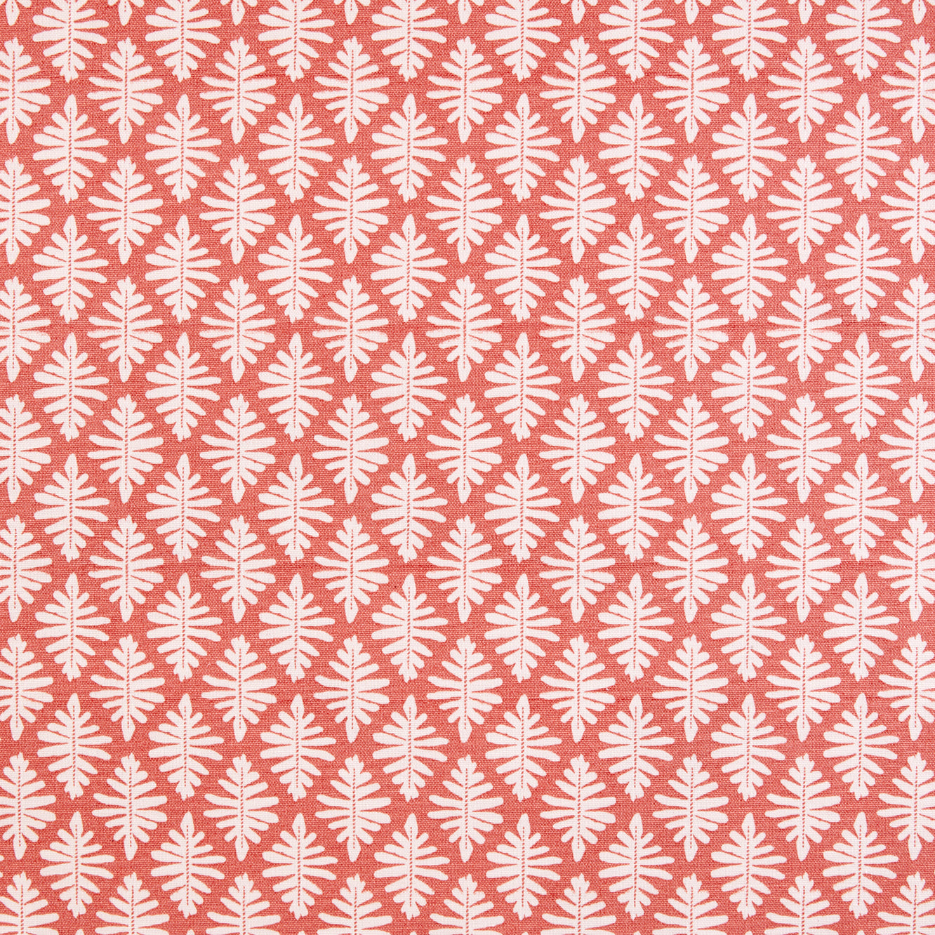 Detail of fabric in a repeating fern leaf print in white on a coral field.