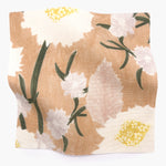Square fabric swatch in a playful floral print in shades of pink, white, yellow and green on a coral field.
