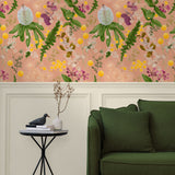 A maximalist living room with a wall papered in a large-scale botanical print in pink, yellow, green and coral.