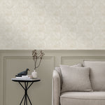 Living room with a wall papered in a textural painted print in tan on a cream field.