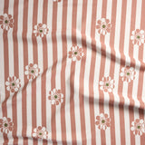 A close-up of a fabric pattern featuring vertical dusty rose and white stripes with scattered daisy-like flowers in white, dusty rose, and olive green.
