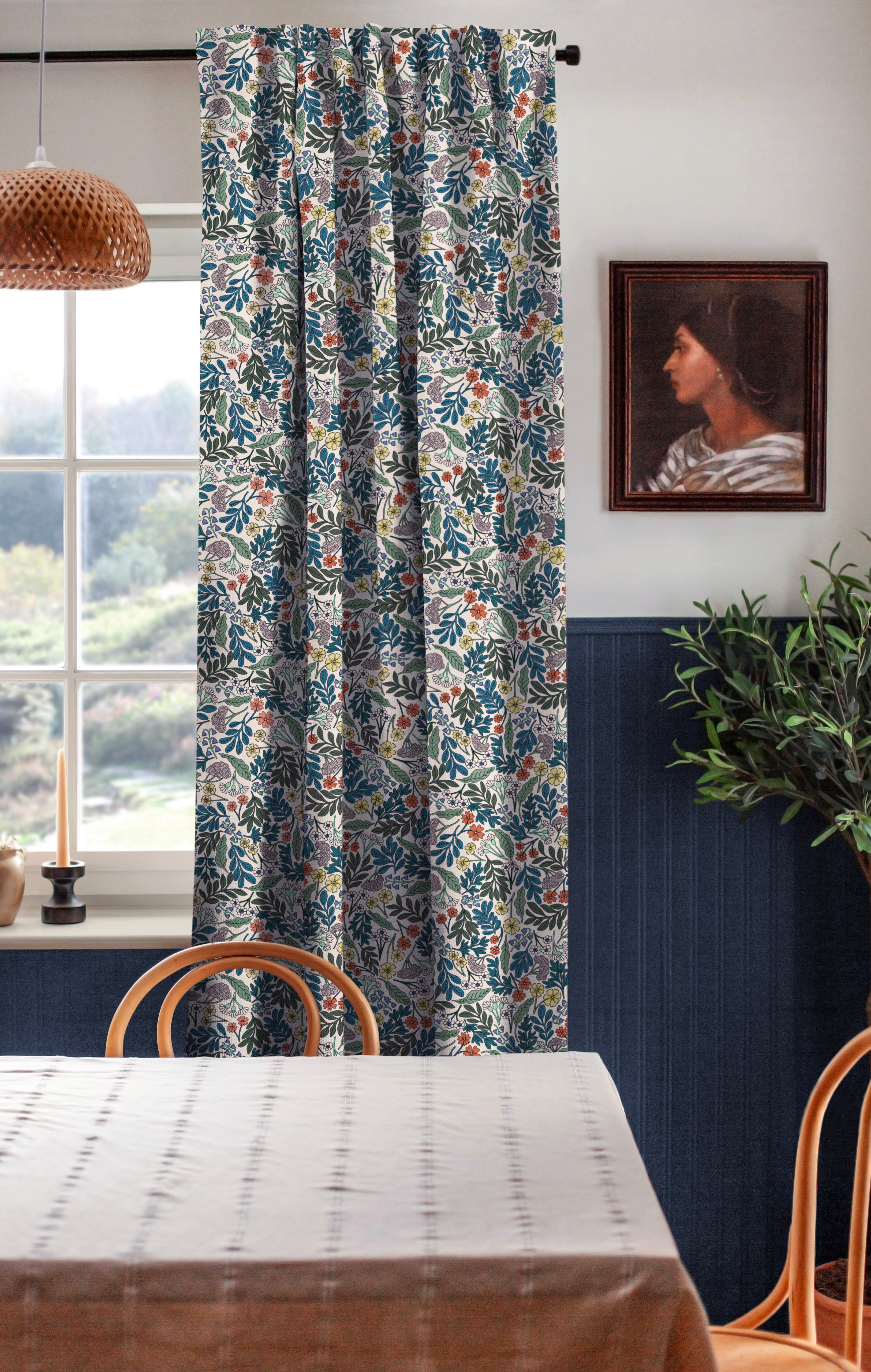 A cozy dining room tableau with a large window and curtains in a small-scale floral print.
