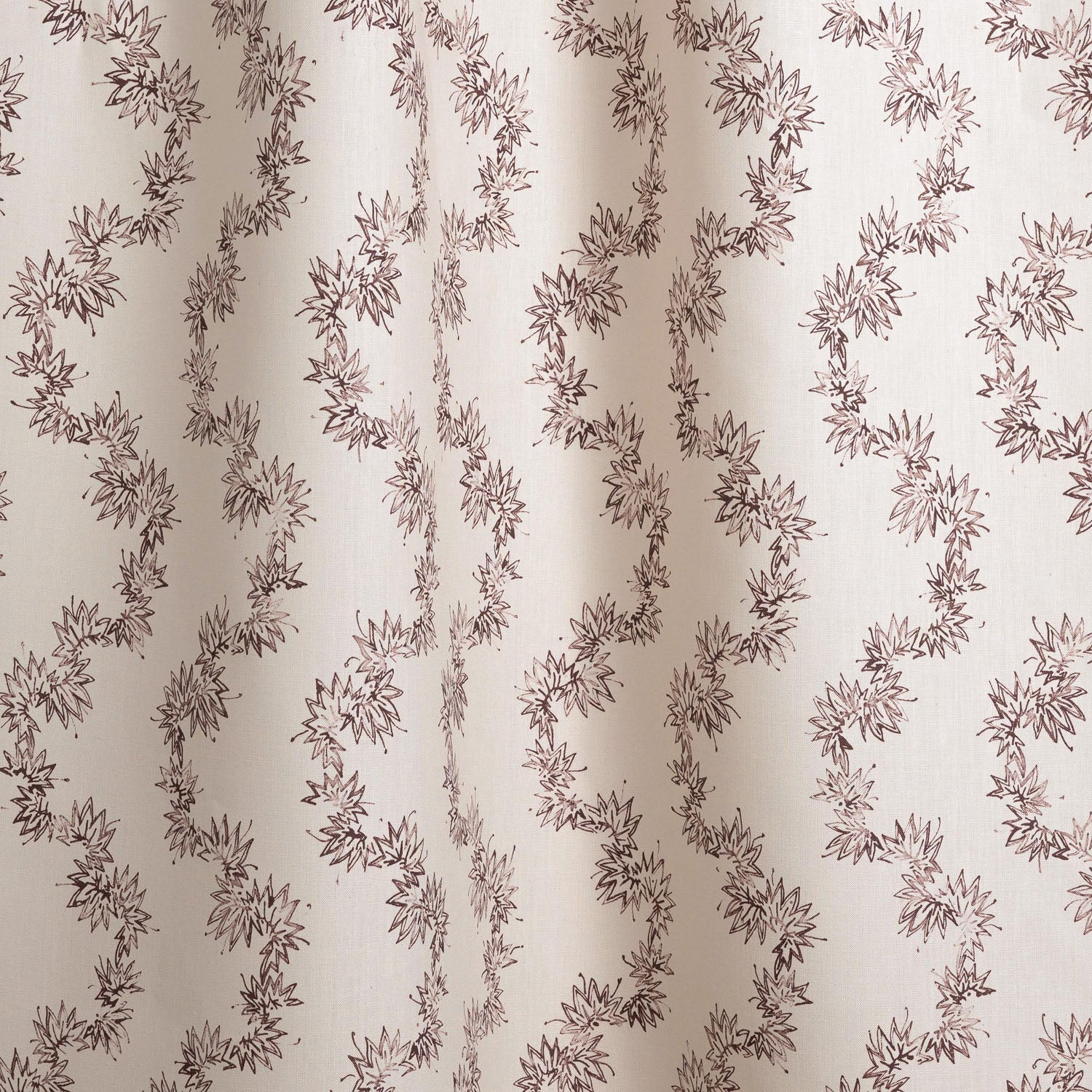 Draped fabric with stripe pattern of stylized dark wine purple leaves on a beige background