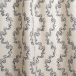 Draped fabric with stripe pattern of stylized dark blue leaves on a beige background