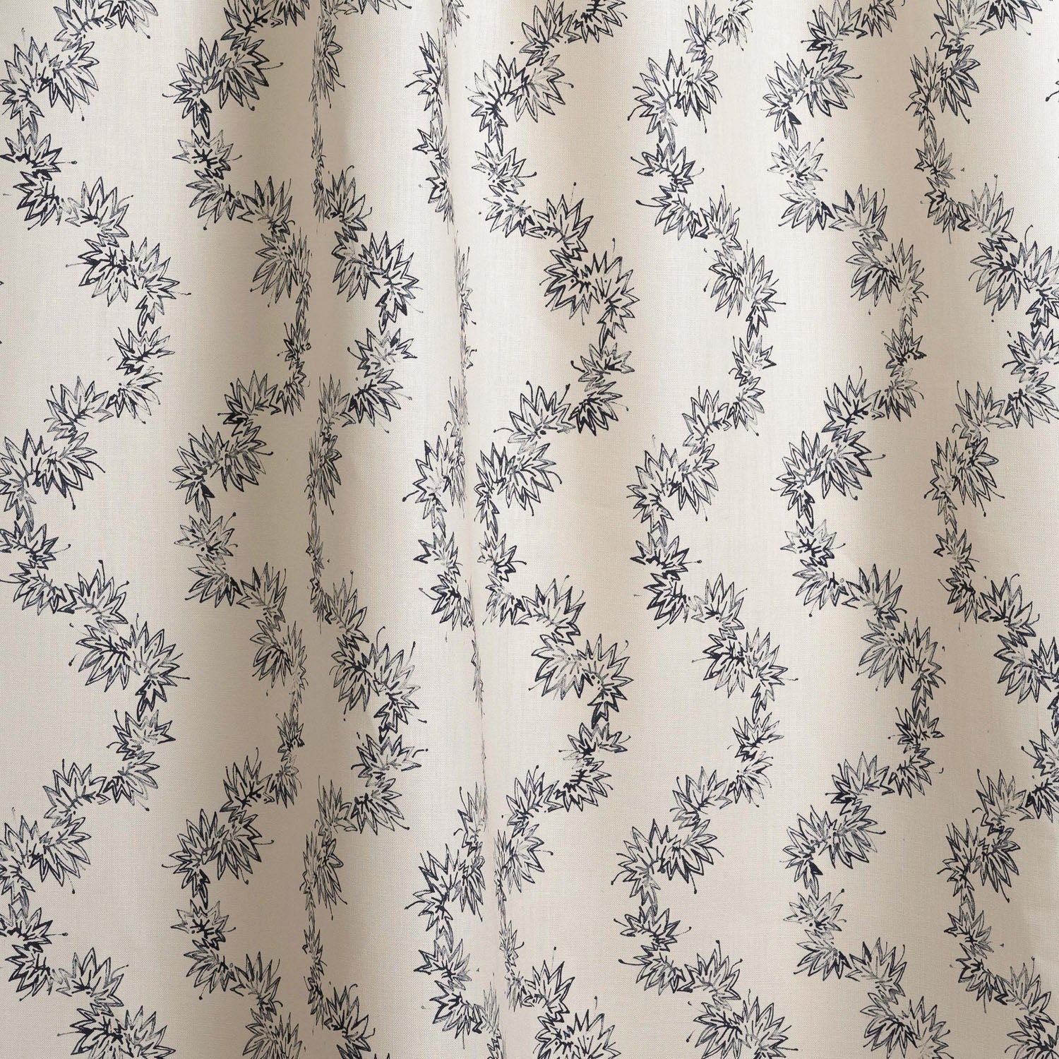 Draped fabric with stripe pattern of stylized dark blue leaves on a beige background