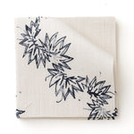 Fabric swatch with stripe pattern of stylized dark blue leaves on a beige background
