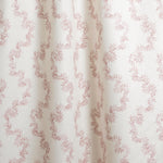 Draped fabric with stripe pattern of stylized pink leaves on a beige background