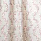 Draped fabric with stripe pattern of stylized pink leaves on a beige background