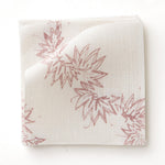 Fabric swatch with stylized leaf design in pink on white. 