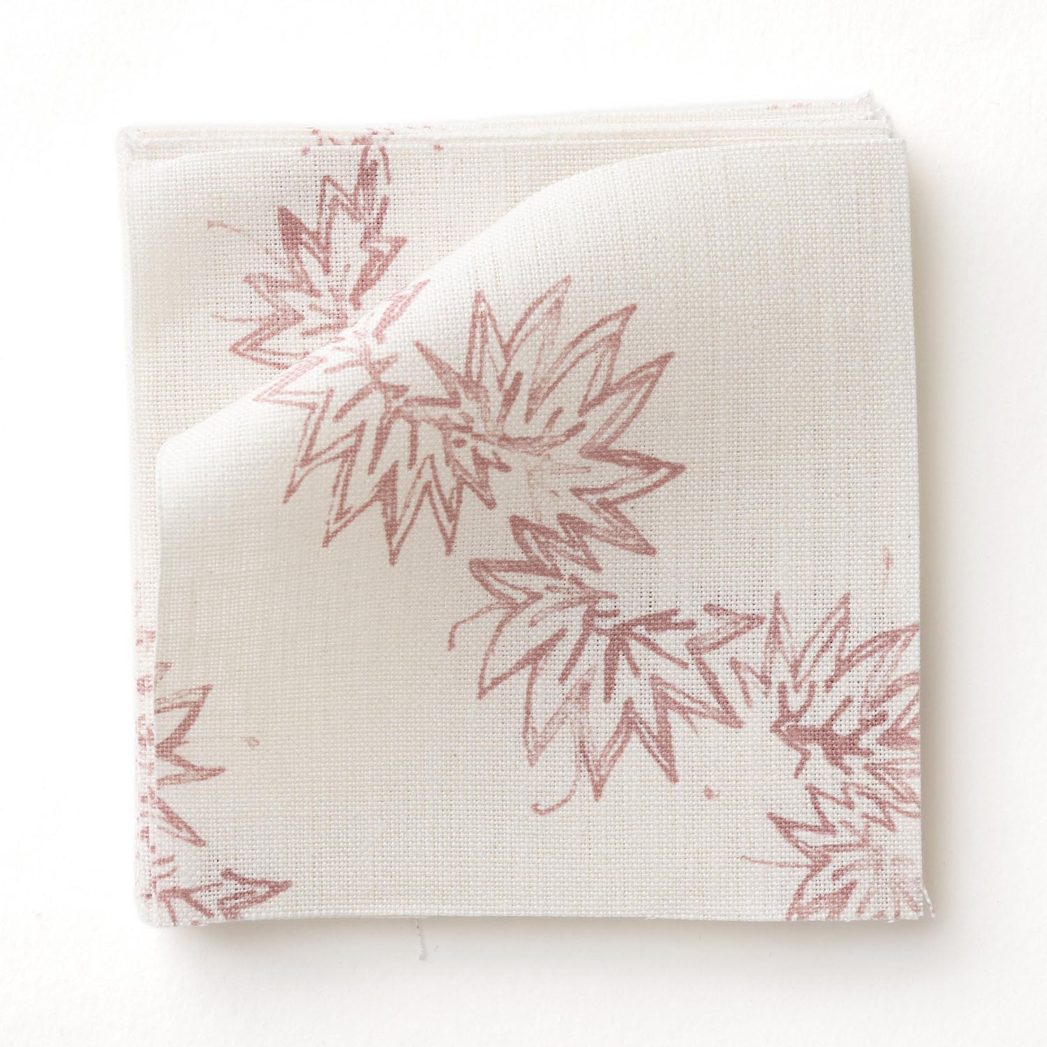 Fabric swatch with stylized leaf design in pink on white. 
