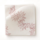 Fabric swatch with stylized leaf design in pink on white. 