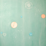 Detail of a wallpaper in a paint splatter print in metallic multicolor pastels on a green field.