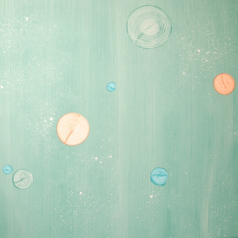 Detail of a wallpaper in a paint splatter print in metallic multicolor pastels on a green field.