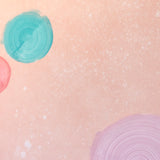 Detail of a wallpaper in a paint splatter print in metallic multicolor pastels on a light pink field.