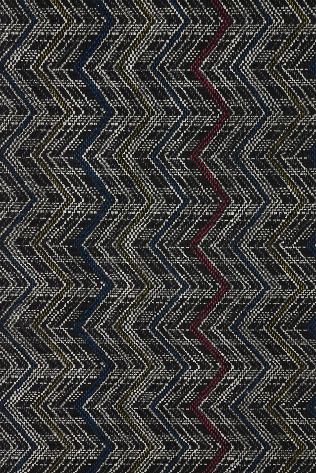 Broadloom carpet in a graphic herringbone stripe in white with primary color accents on a black field. 