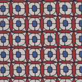 Detail of fabric in a geometric lattice print in red, navy, brown and black.