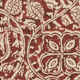 Detail of fabric in a painterly floral paisley in shades of red and brown on a tan field.