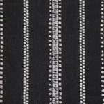 Detail of fabric in an irregular stripe print in white on a black field.