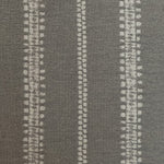 Detail of fabric in an irregular stripe print in gray on a slate field.