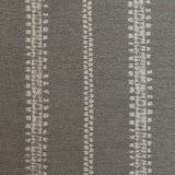 Detail of fabric in an irregular stripe print in gray on a slate field.