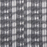 Detail of fabric in a textural shibori print in shades of charcoal on a greige field.