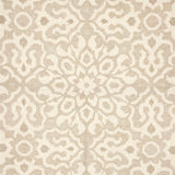 Close up of a handwoven rug in an ornate damask medallion design in cream on a beige field. 