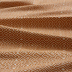 Close-up of yellow fabric with geometric pattern gently folded