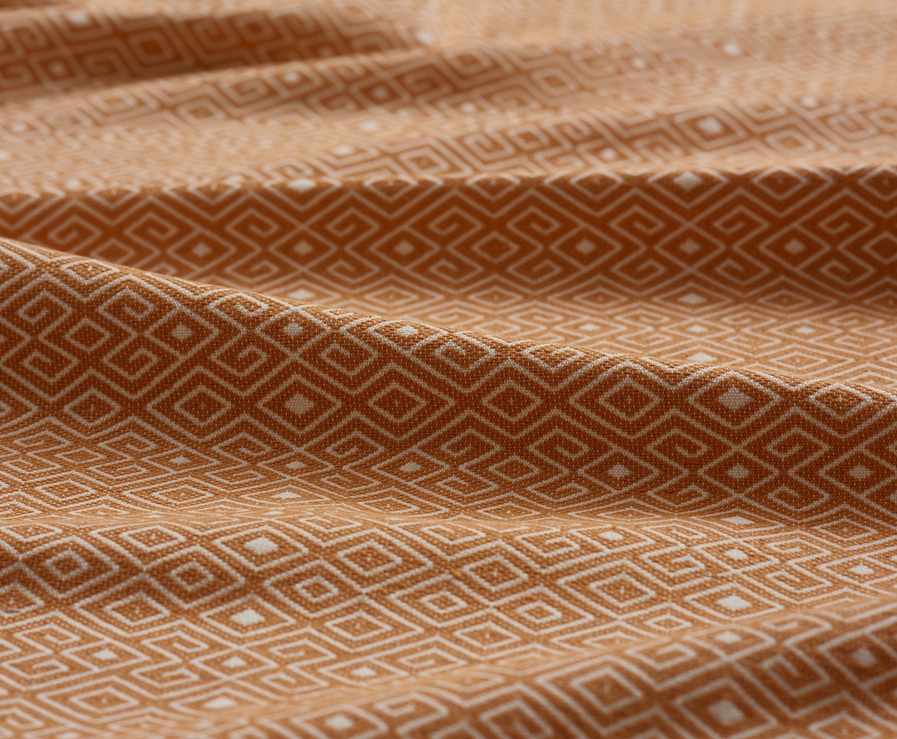 Close-up of yellow fabric with geometric pattern gently folded