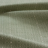 Lightly folded fabric swatch with a geometric diamond design in green.
