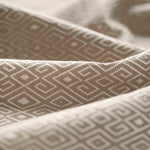 Close-up of textured fabric with geometric pattern in beige gently folded