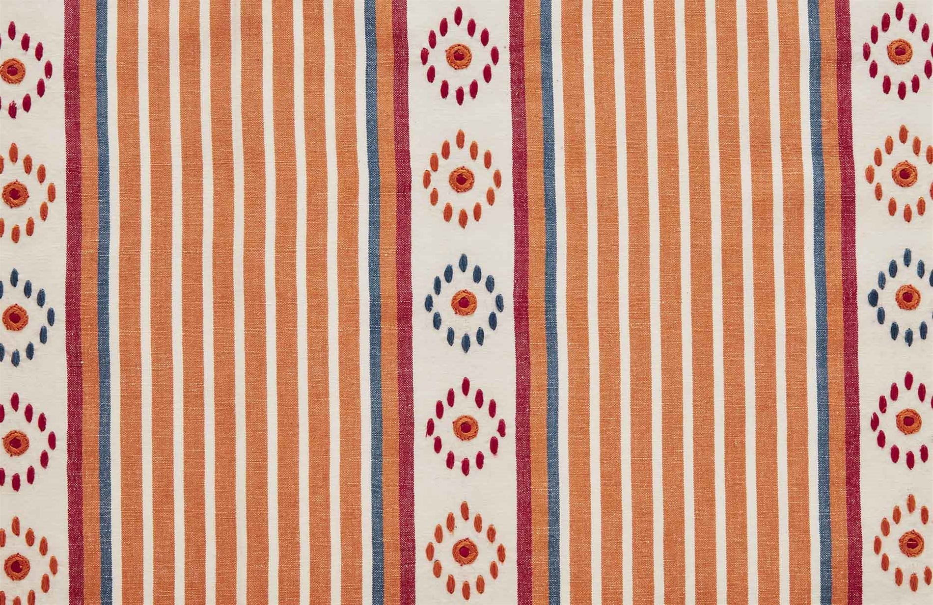 Detail of fabric in a global stripe print in shades of orange, blue and red on a cream field.
