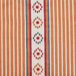 Detail of fabric in a global stripe print in shades of orange, blue and red on a cream field.