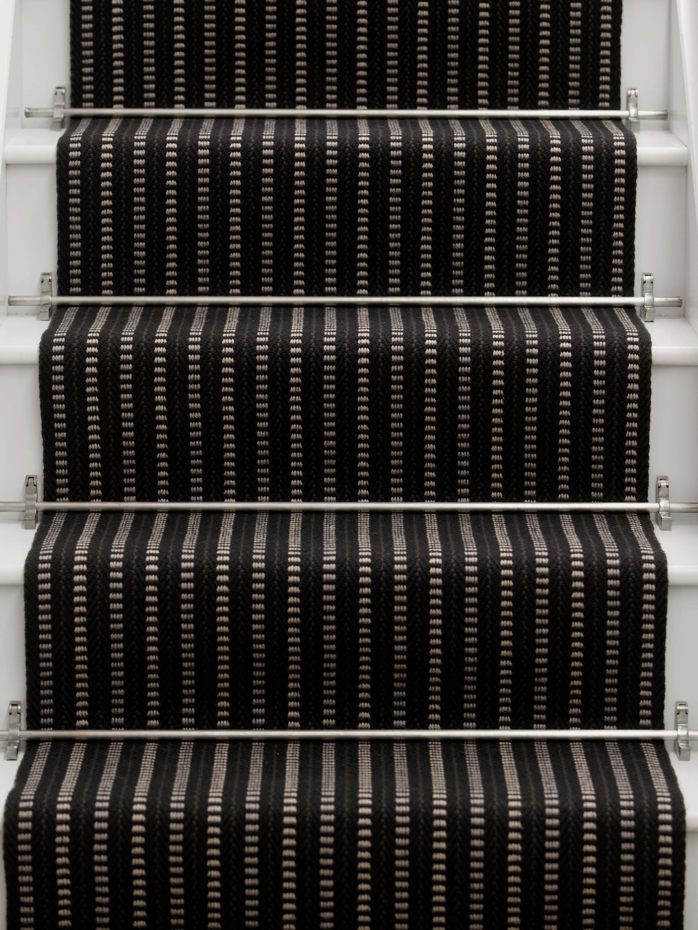 Striped flatweave runner in black and white on white staircase