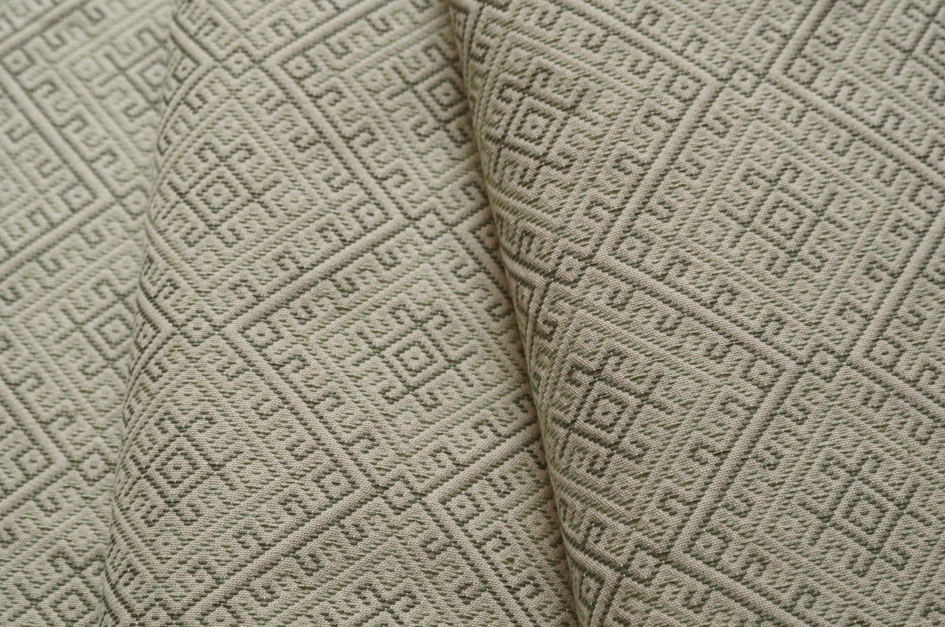Close-up of textured beige fabric with geometric pattern