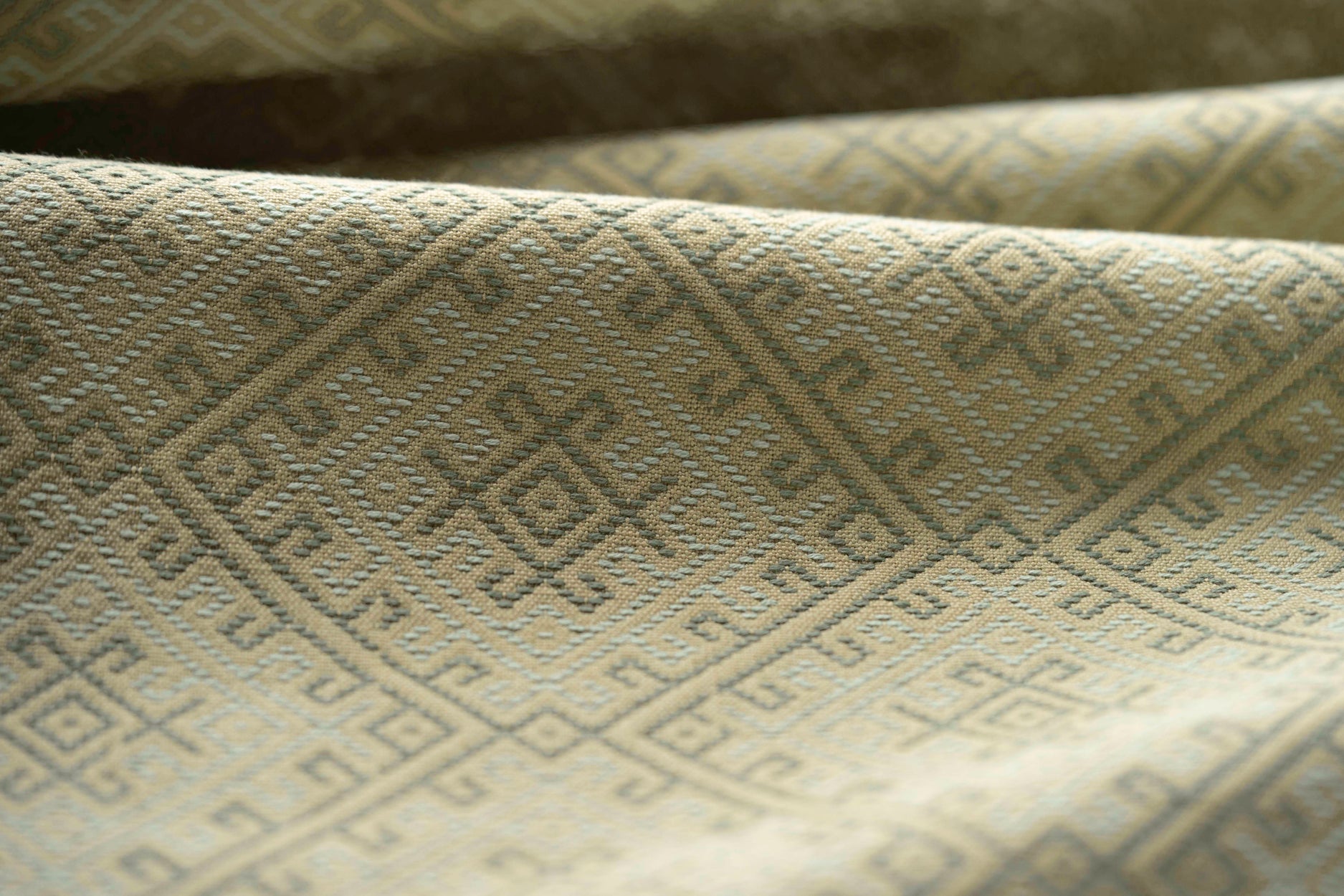 Close-up of textured green fabric with geometric pattern