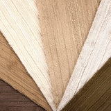 Array of froadloom carpet samples with ribbed and cut pile stripe in neutral colors from brown to ivory.