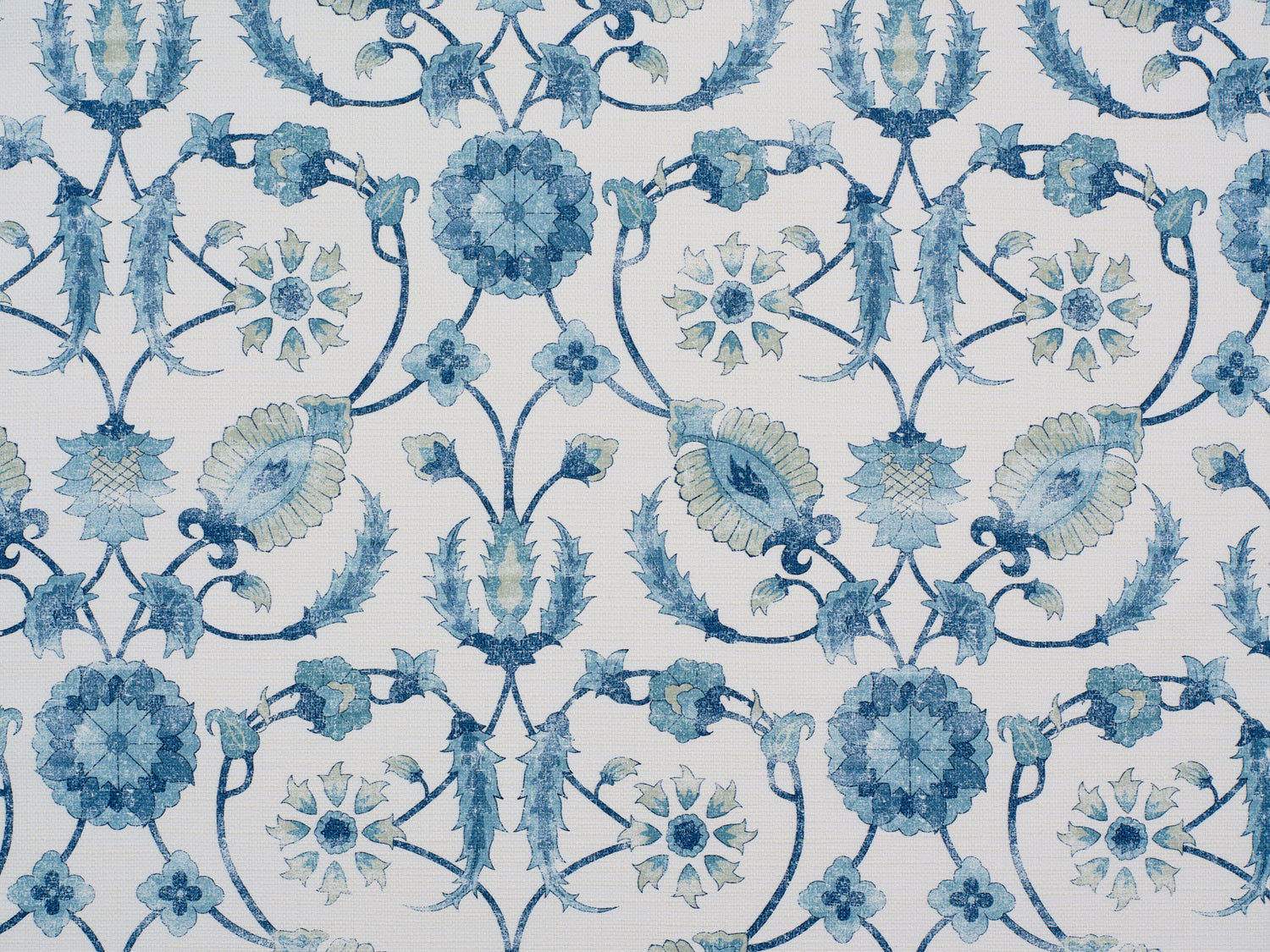 Detail of fabric in a floral paisley print in shades of navy and green on a cream field.