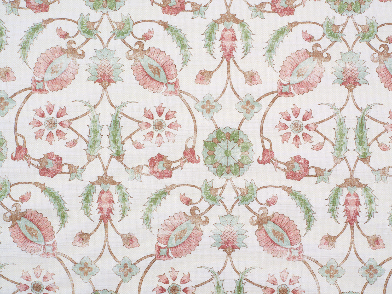 Detail of fabric in a floral paisley print in shades of rust and green on a cream field.
